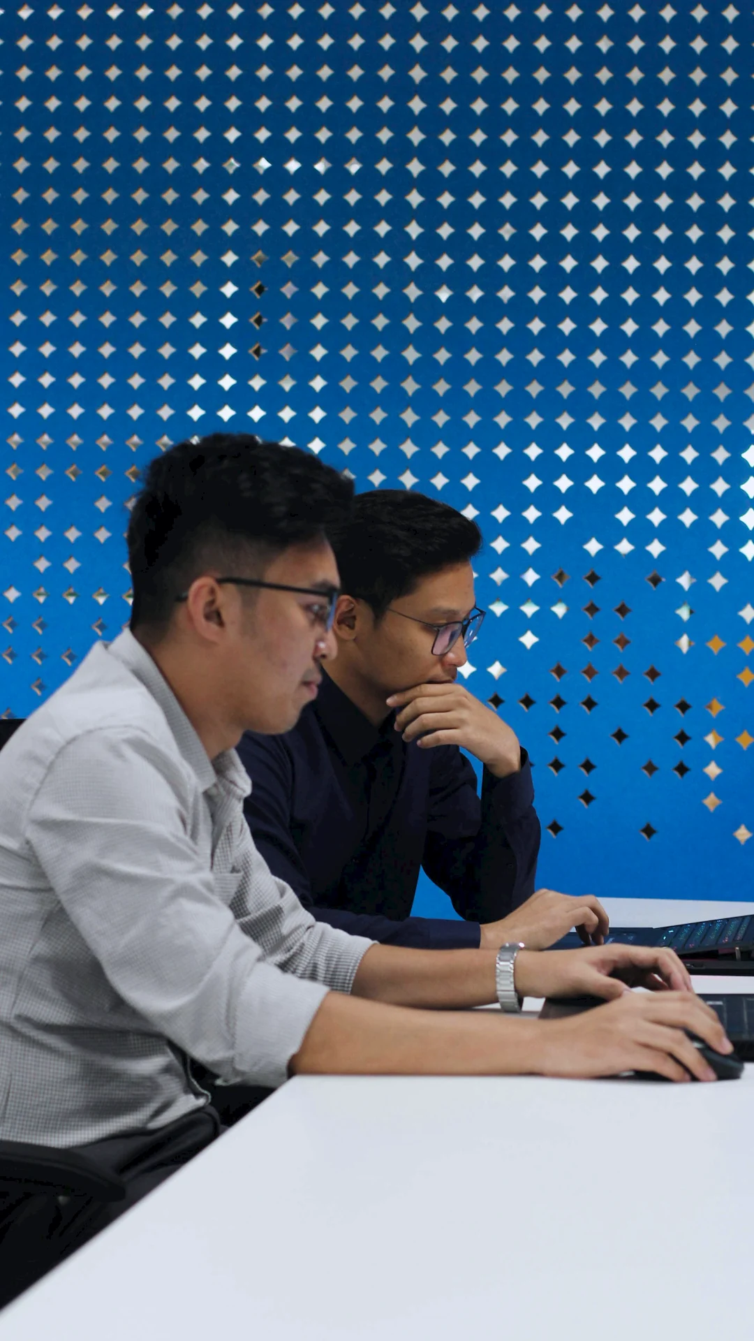 Two colleagues working attentively on laptops